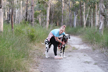 Young girl hugging a dalmatian puppy on a bush track in Australia
