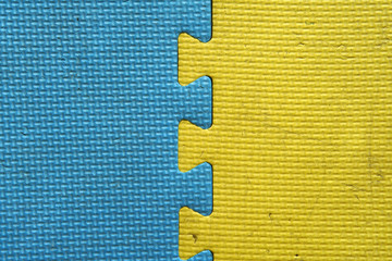 old and dirty yellow and blue foam or rubber floor and colorful soft board on top view for baby children protect and play on playground or kid playroom and for texture or background with wallpaper