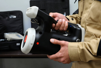 New radiation detectors testing. Dosimetrist holding a handheld radiation isotope identifier, black...