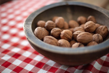 Walnuts in old wooden bowl. on kitchen table