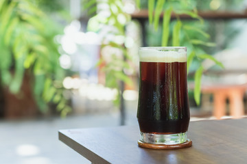 Sparkling Nitro Cold Brew Coffee ready to drink.Outdoor cafe in tropical design.