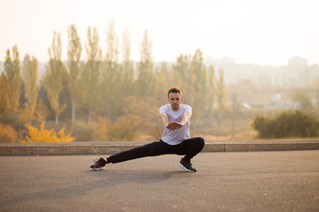 Young male jogger athlete training and doing workout outdoors