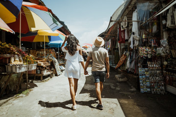 Obraz na płótnie Canvas couple enjoying their time looking for souvenir in the market