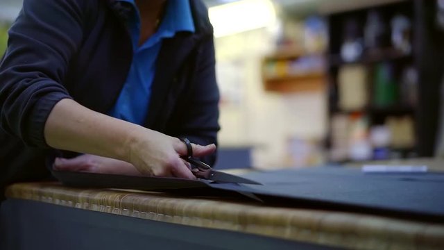 worker sewing shop cuts material artificial leather cuts scissors