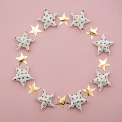 White and gold star decorations on a pastel pink. Seasonal festive background