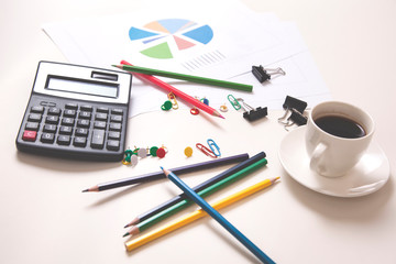 calculator with colorful pencils and coffee on desk