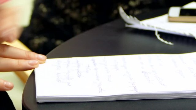 The left-hander is recording in the notebook.