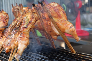 Grilled whole chicken on the flaming grill. Grilled whole chicken marinated in honey and soy sauce.