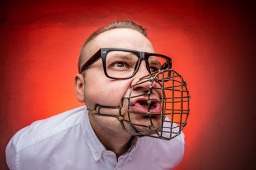 Angry and agressive man with dog muzzle basket shouting