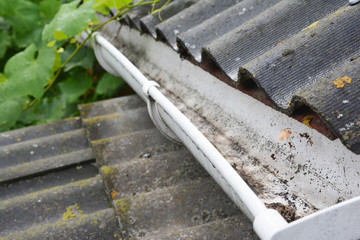 Rain gutter and asbestos roof. Roof gutter pipeline in rainy autumn weather