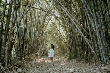 stylish young woman taking picture for social media in bamboo fo