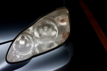 The headlights of car are cloudy with dark tone in parking area. © thongchainak