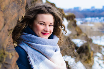 girl with curtains in winter near the cliff