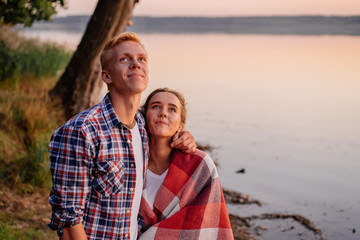 Young beautiful couple at sunset at the lake