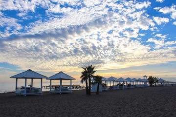 Sunset on the beach with white bungalows 