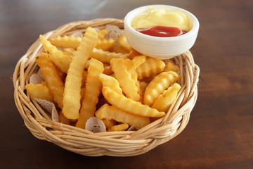 French fries in a basket are placed on the table.