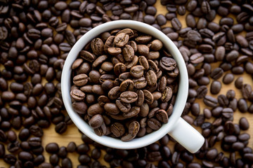 Close up of white coffee cup full of coffee beans background with copy space