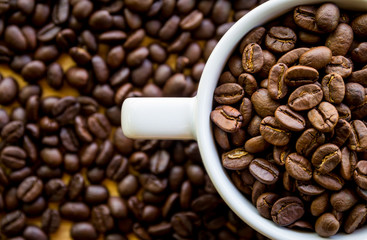 Close up of white coffee cup full of coffee beans background with copy space
