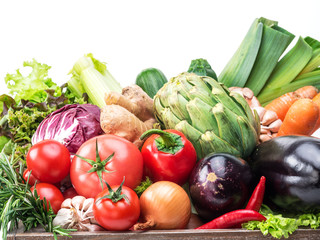 Fresh multi-colored vegetables in wooden crate.