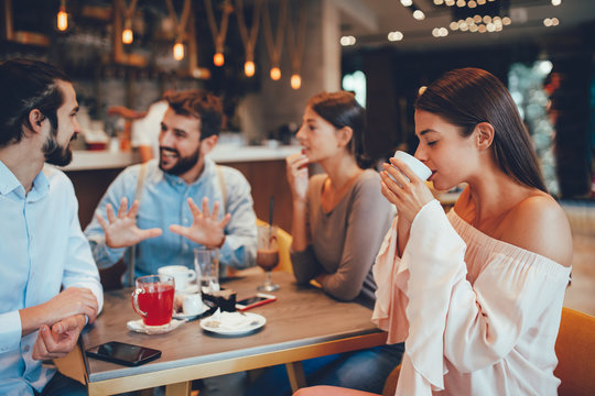 Young woman enjoys coffee with friends in a cafe