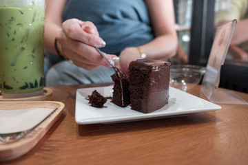 woman cutting a chocolate cake with fork, unhealthy food,dessert 