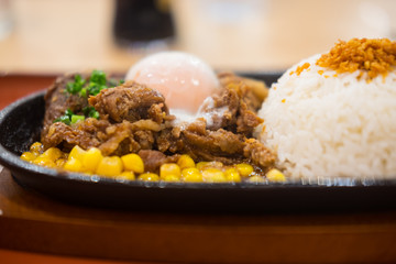 Pork teppanyaki with egg and corn in hot plate