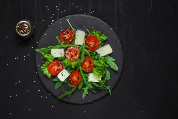 salad - arugula, cheese, tomatoes, lettuce and sesame (Healthy salad from fresh vegetables). Vegan food. Flat lay. Diet menu. Top view
