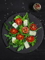 salad - arugula, cheese, tomatoes, lettuce and sesame (Healthy salad from fresh vegetables). Vegan food. Flat lay. Diet menu. Top view