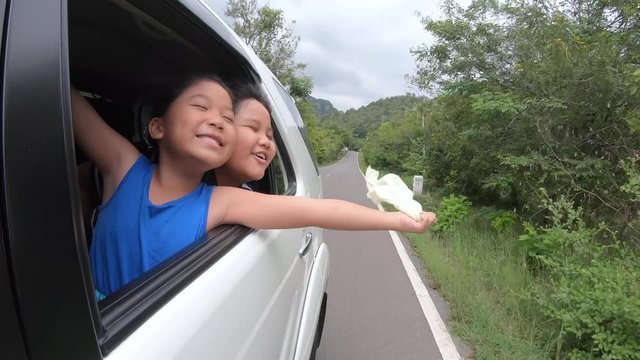 Happy Girl and boy Playing with cloth on Window Car, Family Traveling on Countryside concept