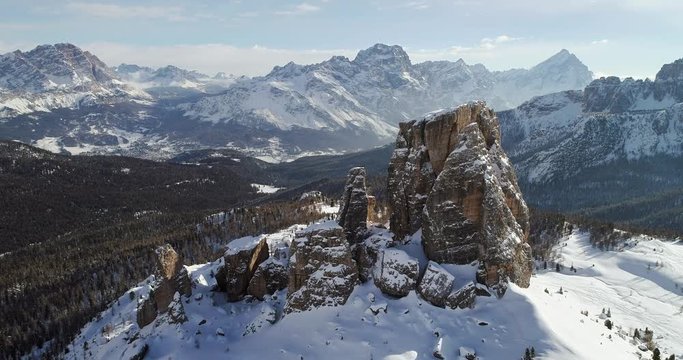Forward aerial toward majestic Cinque Torri rocky mounts showing woods forest valley. Sunny day with cloudy sky.Winter Dolomites Italian Alps mountains outdoor nature establisher.4k drone flight