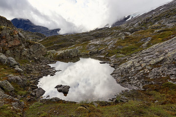 Wolken spiegeln sich im Teich am Berg eines Gletschers