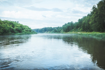 Morning on the calm river with forest on their bank
