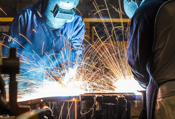 worker with protective mask welding metal