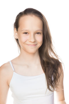 Beautiful smiling caucasian preteen girl in tank top with loose hair isolated on white. Studio portrait
