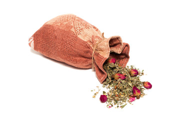 Tea from petals and rosebuds scattered on the table from the bag