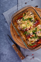 baked chicken legs with tomatoes and onions and cheese Chicken Casserole Menu and Restaurant Concept On a gray background