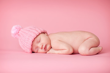 Newborn Baby Girl in Knit Hat, Isolated on Pink