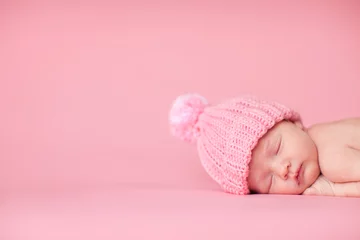 Fototapeten Newborn Baby Girl in Knit Hat, Isolated on Pink, Room for Text © IdeaBug, Inc.