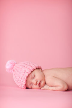 Newborn Baby Girl In Knit Hat, Isolated On Pink, Room For Text