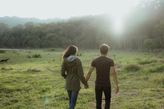 man and woman walking together in nature