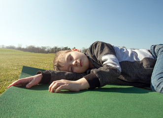Boy sleep outdoors in the autumn park