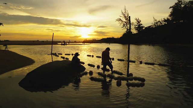 time lapse beautiful sunset above Nai Harn lake. fishermen catching shellfish in the lake.