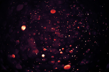 Light and flare in red tones bokeh abstract background.