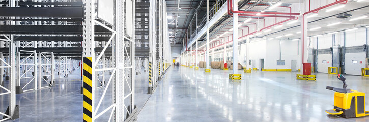 Empty huge distribution warehouse with high shelves and pallets