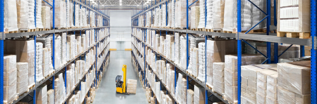 Large distribution warehouse passway with high shelves and forklift