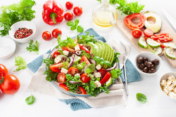 greek style avocado tomato salad with feta cheese, olives, cucumber, onion, lettuce