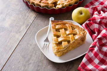 Homemade apple pie slice on wooden table. Copyspace
