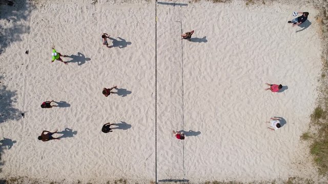 Group of people playing beach volley ball. Aerial vertical view