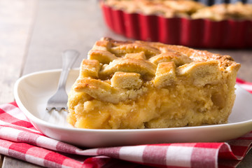 Homemade apple pie slice on wooden table