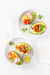 avocado boats stuffed with hummus, tomatoes, radish, roasted chickpea